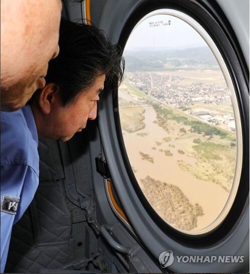 (도쿄=연합뉴스) 아베 신조(安倍晋三·오른쪽) 일본 총리가 최근 폭우 피해를 본 서부 피해지역을 11일 자위대 헬기에서 바라보고 있다.
