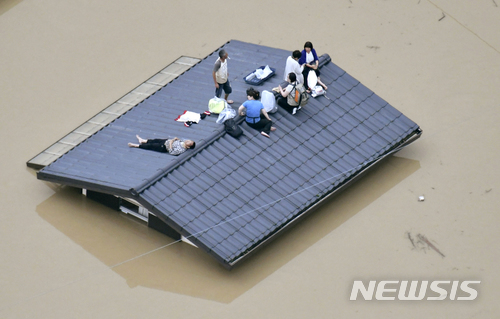 7일 일본 오카야마(岡山)현 구라시키(倉敷)시에서 지붕에 대피한 주민들이 구조를 기다리고 있다. (출처: 뉴시스)