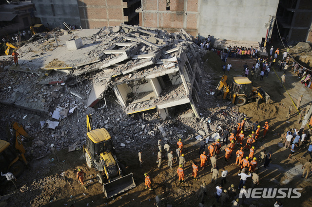 【뉴델리(인도)=AP/뉴시스】신축 중이던 6층 건물이 붕괴되는 사고가 발생한 인도 뉴델리의 샤베리 마을의 사고 현장에서 구조대가 무너진 건물 잔해를 뒤지며 생존자가 있는지 수색하고 있다.