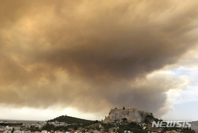 23일(현지시간) 그리스 수도 아테네 서부의 산림에서 발생한 산불로 하늘이 짙은 연기로 뒤덮여 있다. (출처: 뉴시스)