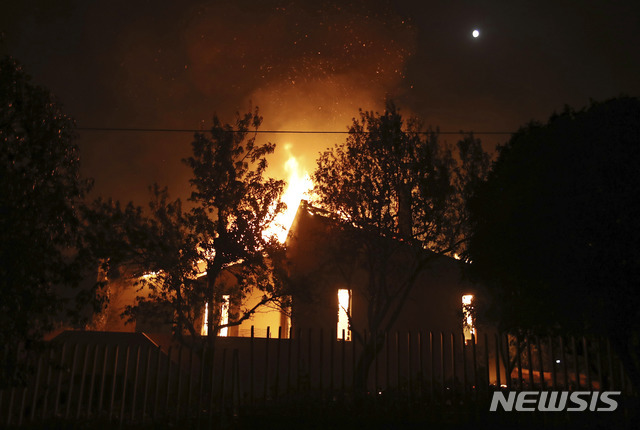 【마티 (그리스) = AP/뉴시스】 그리스 아테네시 인근 마티에서 23일(현지시간) 발생한 산불로 주택들이 불타고 있다.