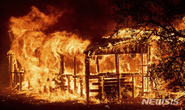 미 캘리포니아 레딩시에 위치한 한 건물이 26일(현지시간) 산불이 번지면서 불타고 있다. (출처: 뉴시스)