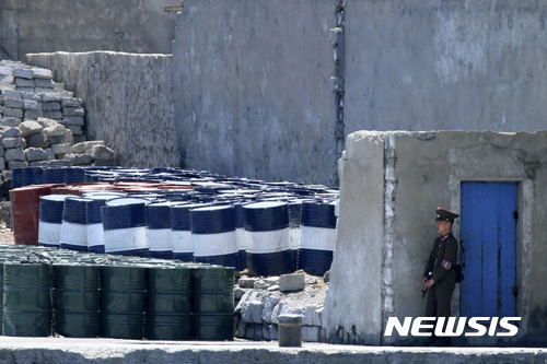 북한 군인이 지난 2016년 5월8일 중국 단둥(丹東)과 인접한 신의주에서 정제 석유 제품을 지키고 있다. 2017.09.23 (출처: 뉴시스)