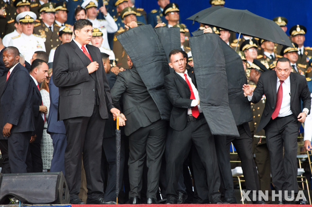 4일 군창설 기념식 행사에서 니콜라스 마두로 대통령 연설을 하는 도중에 폭발물이 터지자 그를 감싸는 경호원들. (출처: 뉴시스)