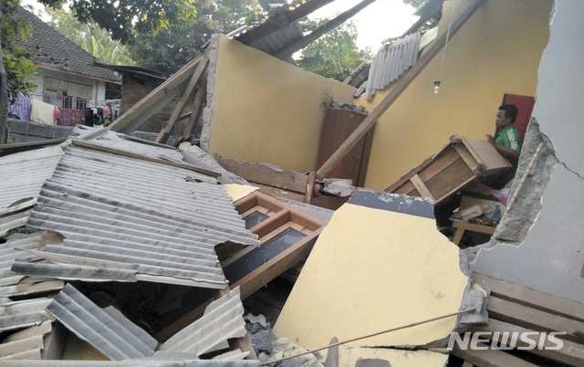 지난달 29일 새벽 규모 6.4의 지진이 발생한 인도네시아의 유명관광지 롬복에서 한 남성이 무너진 가옥을 둘러보고 있는 모습 (출처: 뉴시스)