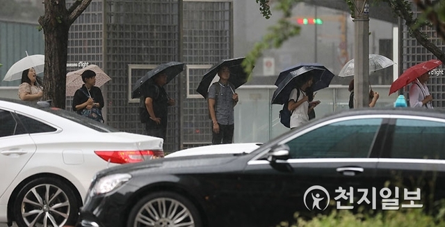 [천지일보=남승우 기자] 연일 기록적인 폭염이 계속되고 있는 6일 오전 서울 강남역 인근에서 소나기가 내리자 시민들이 우산을 쓴 채 버스를 기다리고 있다. ⓒ천지일보 2018.8.6