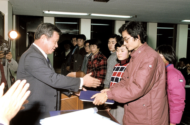 1986년 고 최종현 회장(왼쪽)이 해외 유학을 앞둔 한국고등교육재단 장학생들에게 장학증서를 전달하고 있다. (제공: SK그룹)