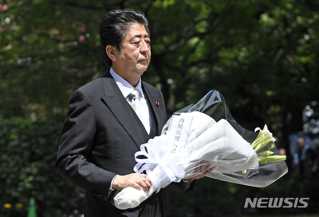 아베 신조 일본 총리가 15일 도쿄 부도간에서 열린 2차세계대전 전몰자 추모식에 참석해 꽃다발을 바치려 하고 있다. (출처: 뉴시스)