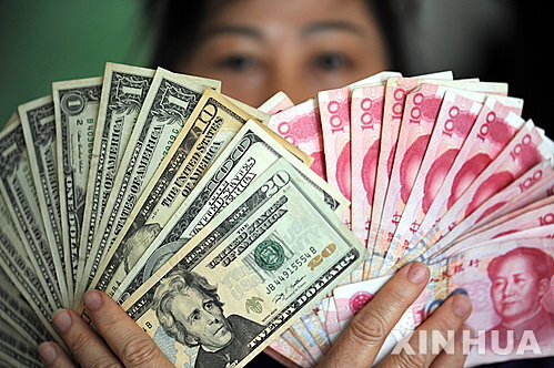 도널드 트럼프 미국 대통령이 20일(현지시간) “중국이 환율을 조작하고 있다”고 공개 비판에 나섰다. 사진은 중국 하이난성 츙하이 은행에서 한 은행원이 달러화(왼쪽)과 위완화를 손에 들고 있는 모습. (출처: 뉴시스)