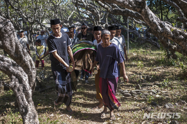 인도네시아 롬복섬에서 지난 12일 주민들이 강진 희생자를 매장지로 운구하고 있다. 롬복에서는 20일 또다시 강진이 발생했다. (출처: 뉴시스)