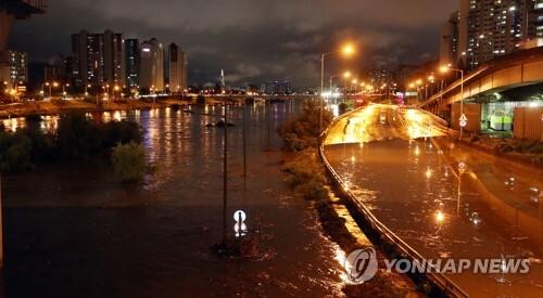 (서울=연합뉴스) 서울지역에 호우경보가 발효된 28일 밤 서울 중랑천 도로가 물에 잠겨 있다. 
