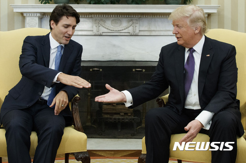 도널드 트럼프 미국 대통령(오른쪽)과 쥐스탱 트뤼도 캐나다 총리가 지난해 2월 백악관 대통령 집무실에서 악수를 나누고 있다. (출처: 뉴시스)