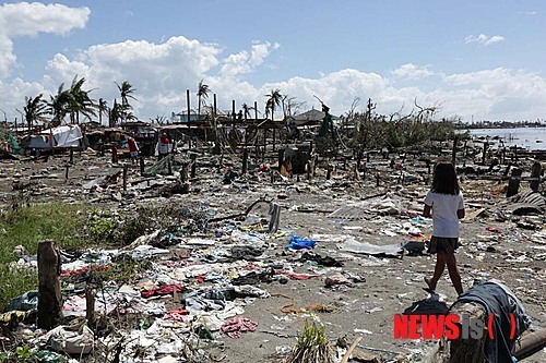 지난 2013년 11월 19일(현지시각) 태풍 하이옌이 처참하게 휩쓸고 간 필리핀 피셔맨 마을의 잔해 사이로 한 소녀가 걸어가고 있는 모습. (사진출처: 뉴시스)