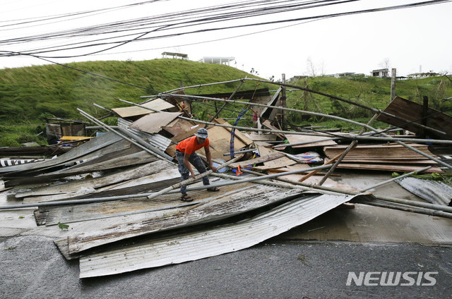 [투게가라오(카가얀)=AP/뉴시스] 필리핀 구조대원이 15일 북부 카가얀 주 투게가라오 지역에서 태풍 망쿳에 강타돼 무너진 구조물을 수습하고 있다.