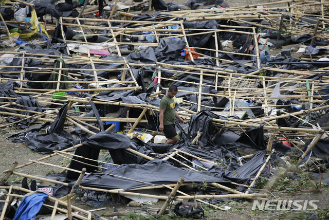 필리핀 카가얀주 투게가라오에서 16일 경찰 한 명이 슈퍼태풍 망쿳이 휩쓸고 지나가면서 완전히 파괴한 대피소 텐트들 사이를 지나가고 있다. (출처: 뉴시스)