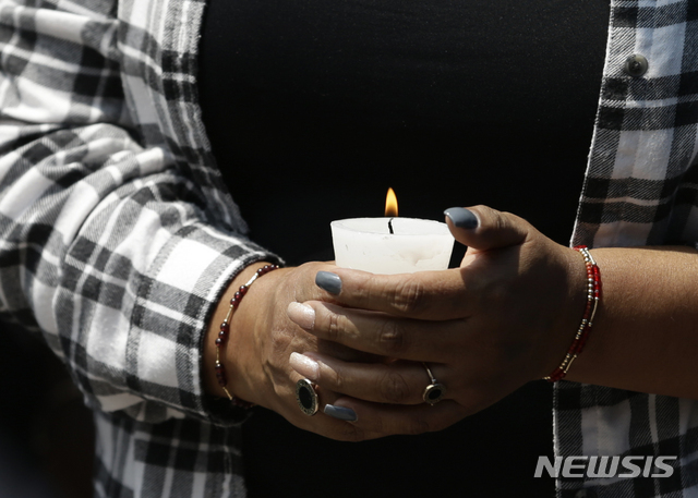 (AP Photo/뉴시스) 19일(현지시간) 멕시코 멕시코시티에서 열린 지진 피해자 추모식에서 1년 전 진도 7.1의 지진으로 숨진 피해자의 유가족이 촛불을 들고 애도하고 있다. 지난해 9월 19일 멕시코시티에서 발생한 이 지진으로 49명이 사망했다.