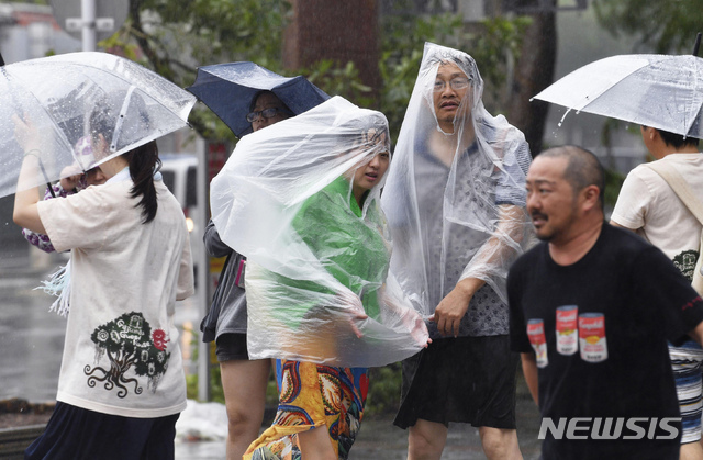 29일 태풍 짜미가 일본 오키나와 나하시 인근 해상에 접근한 가운데 나하시에서 시민들이 강풍을 뚫으며 걷고 있다. (출처: 뉴시스)