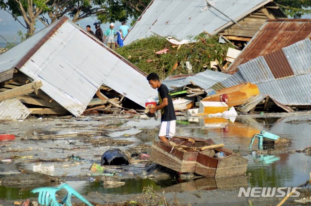 인도네시아 중부 술라웨시 섬 팔루 일대에 28일 규모 7.5 지진과 쓰나미가 강타했다. 현지 주민이 29일 쓰나미에 휩쓸려간 집이 있던 주변에서 당장 사용할 가재도구를 찾고 있다. (출처: 뉴시스)