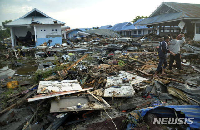 [팔루=AP/뉴시스] 인도네시아 술라웨시 섬 팔루에서 29일 주민들이 강진과 쓰나미로 파괴된 곳을 살펴보고 있다. (출처: 뉴시스)