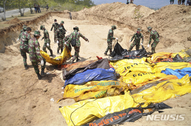 【팔루=AP/뉴시스】인도네시아 술라웨시섬 팔루에서 2일 군인들이 지진 및 쓰나미로 사망한 시신들을 집단매장하기 위해 준비하고 있다.