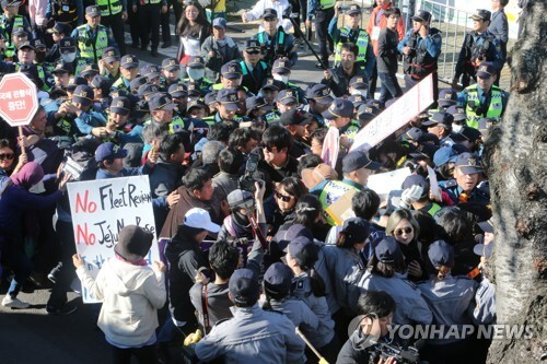 (서귀포=연합뉴스) 11일 제주 서귀포시 강정마을 평화센터 주변 사거리에서 해군 국제관함식 반대 주민과 시민사회단체 활동가들이 경찰에 둘러싸여 시위를 벌이고 있다.