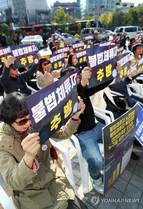(서울=연합뉴스) 14일 오후 서울 청계광장 인근에서 열린 불법체류자 추방 및 난민법 폐지 촉구 집회에서 참가자들이 손팻말을 들고 있다.