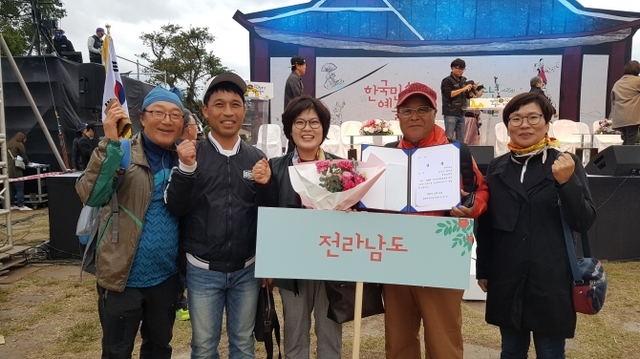 지난 12일부터 3일간 제주도 성읍민속마을에서 개최한 ‘제59회 한국민속예술축제에서 대상을 수상한 밤골농악단이 상장과 꽃을 들고 기념사진을 찍고 있다. (제공:보성군) ⓒ천지일보 2018.10.15