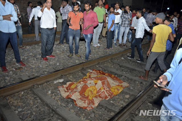 인도 북부 펀자브 주 암리차르에서 19일(현지시간) 달리는 열차가 인파를 덮쳐 최소 50명이 사망했다. 사진은 사고 현장의 모습으로, 희생자 위에 천이 덮여있다. (출처: 뉴시스)