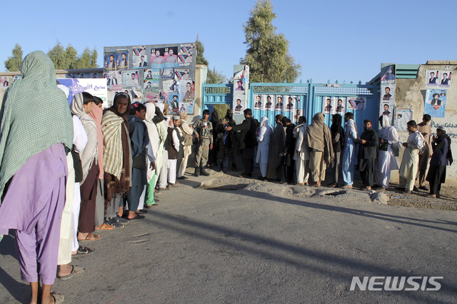 【카불=AP/뉴시스】아프가니스탄 남부 헬만드 주에서 20일 8년 만에 실시한 하원선거 투표에 참여하려는 유권자들이 삼엄한 경계가 펼쳐진 투표소 앞에 길게 늘어서서 차례를 기다리고 있다.