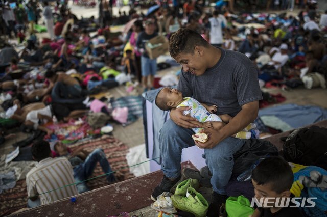 지난 24일 멕시코의 소도시 마파스테펙에서 3개월 된 자신의 아들을 안고 있는 온두라스 출신 캐러밴 이민자. (출처: 뉴시스)