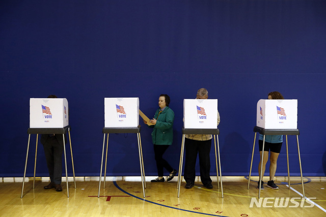 【파사데나=AP/뉴시스】 6일 미 중간선거에 참여한 메릴랜드주 유권자가 투표소에 들어와서 투표용지를 받은 뒤 기표하기 위해 빈 부스로 가고 있다. 여기서 기표가 끝나면 옆에 설치된 전자기기에서 스캔해 보내야 투표가 끝난다. (출처: 뉴시스)