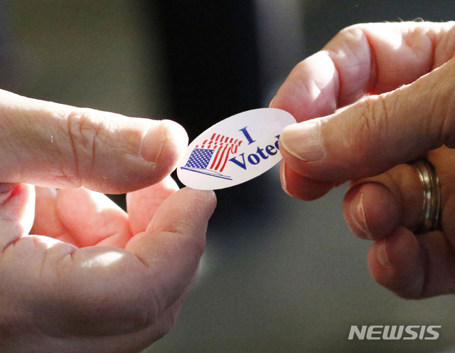 6일(현지시간) 미국 매디슨 지역에서 유권자가 ‘나는 투표했다’는 스티커를 받고 있다. (출처: 뉴시스)