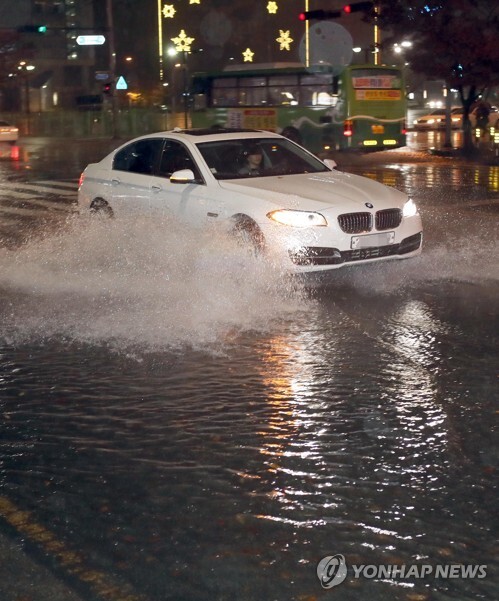 부산지역에 호우주의보가 발령된 8일 오후 부산 해운대구 센텀시티 도로가 침수돼 차량이 물보라를 일으키며 달리고 있다. [부산=연합뉴스]