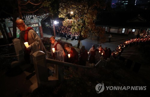 2018 대학수학능력시험을 5일 앞둔 10일 오후 서울 강남구 봉은사에서 열린 수능 촛불기원법회에서 촛불을 든 수험생과 학부모들이 스님들을 따라 사찰을 돌고 있다. (출처: 연합뉴스)