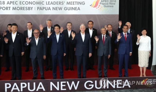 아시아·태평양경제협력체(APEC) 정상회의 마지막날인 18일 개최지 파푸아뉴기니의 수도 포트모르즈비에서 문재인 대통령(뒷줄 가운데), 시진핑 중국 국가주석(앞줄 왼쪽)과 아베 신조 일본 총리(3번째), 마이크 펜스(가운데) 미 부통령 등 참석 정상들이 손을 들며 기념촬영하고 있다. (출처: 연합뉴스)