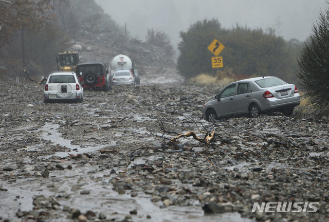 【샌버나디노=AP/뉴시스】미국 캘리포니아주 샌버나디노에서 29일(현지시간) 자동차들이 폭우가 내리면서 진흙탕으로 변해버린 도로를 지나고 있다.