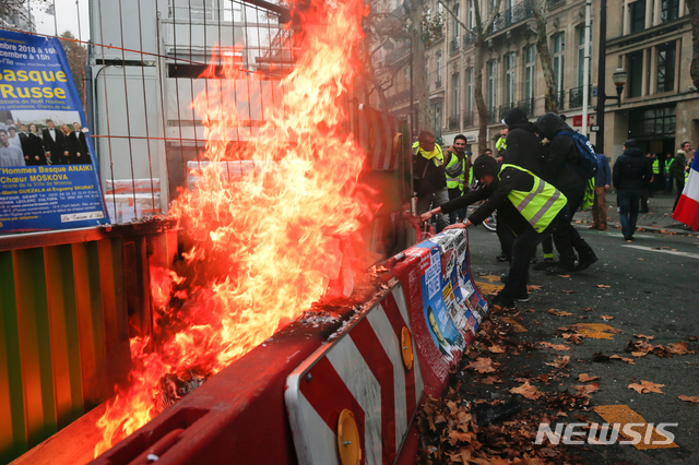 지난달 24일(현지시간) 프랑스 파리에서 기름값 인상 및 생활고에 항의하는 이른바 노란 조끼 대규모 집회가 열려 시위대가 도로에 불을 지르고 있다. (출처: 뉴시스)