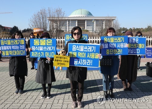 (서울=연합뉴스) 12일 오후 서울 여의도 국회 앞에서 개식용종식시민연대 회원들이 음식물 쓰레기 동물 먹이 사용 금지를 요구하는 퍼포먼스를 하고 있다.