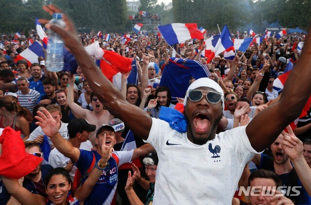 지난 7월 15일(현지시간) 프랑스 파리 샹드 마르스 공원에서 설치된 대형 스크린으로 크로아티아와의 2018 러시아 월드컵 결승전을 지켜보던 시민들이 프랑스가 4대 2로 승리, 우승이 확정되자 환호하고 있다. (출처: 뉴시스)