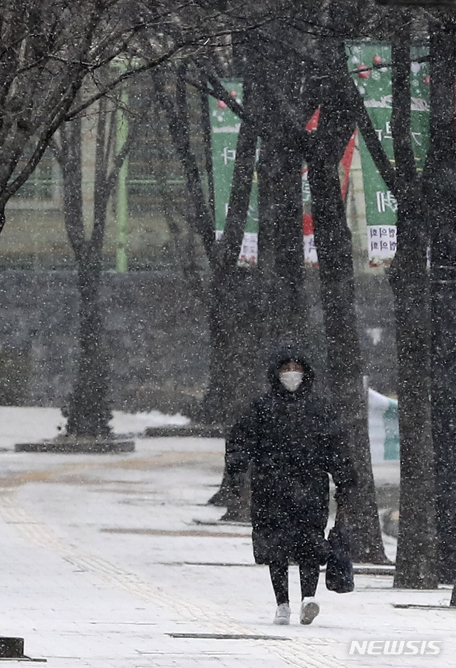 【서울=뉴시스】 아침부터 눈이 내리고 있는 16일 오전 서울 성동구청 인근에서 시민이 눈을 맞으며 발걸음을 재촉하고 있다. 기상청은 