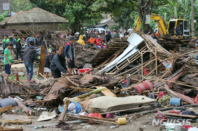 인도네시아 카리타에서 23일 주민들이 하루 전 발생한 쓰나미로 파괴된 주택을 살펴보고 있다. (출처: 뉴시스)