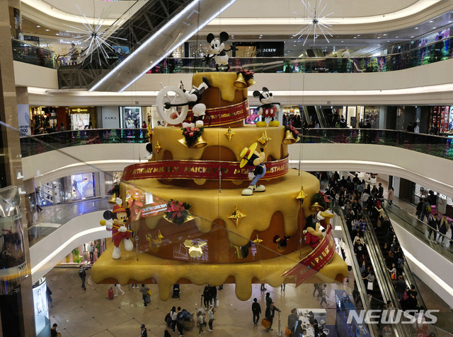 24일(현지시간) 홍콩의 한 쇼핑몰에 성탄절을 축하하기 위해 꾸며놓은 대형 케이크가 사람들의 발길을 끌고 있다. (출처: 뉴시스)