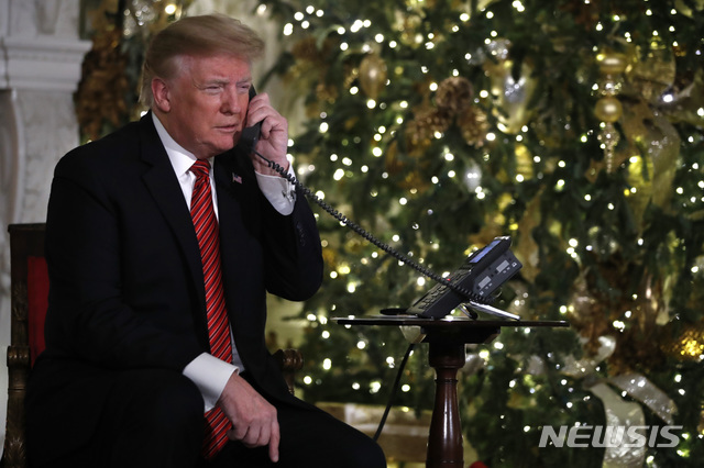 도널드 트럼프 미국 대통령이 24일(현지시간) 백악관에서 북미항공우주방위사령부(NORAD)에 전화를 걸어 산타의 현재 위치를 묻고 있다. (출처: 뉴시스)
