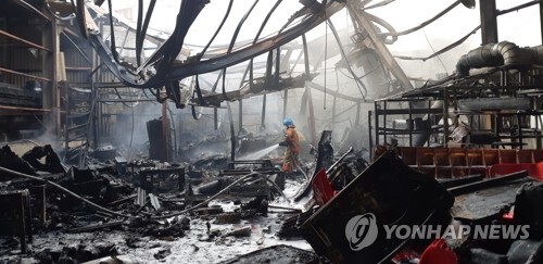 (울산=연합뉴스) 9일 오후 화재로 전소한 울산시 북구 시례동 한 공장 내부에서 소방관이 잔불 제거 작업을 하고 있다.