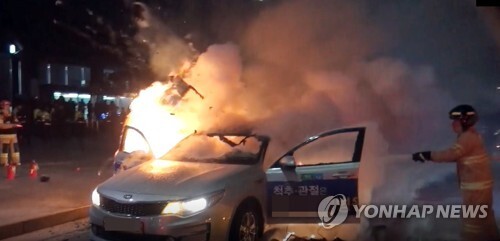 9일 오후 6시께 서울 지하철 5호선 광화문역 2번 출구 앞 도로에서 택시에 불이 났다. 출동한 소방관이 진화하고 있다. (출처: 연합뉴스)