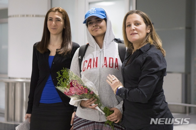 【토론토=AP/뉴시스】가족으로부터 학대를 받았다고 주장하며 탈출한 사우디아라비아 소녀 라하프 무함마드 알쿠눈(가운데)이 12일(현지시간) 망명을 허용한 캐나다 토론토 피어슨 국제공항에 도착해 포즈를 취하고 있다. 오른쪽 여성은 크리스티아 프릴랜드 캐나다 외무장관이다.