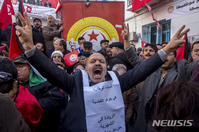 【튀니스=AP/뉴시스】17일(현지시간) 튀니지 수도 튀니스의 전국 노조 본부 앞에서 튀니지 근로자들이 총파업 시위를 벌이고 있다. 튀니지 근로자들은 정부가 실업률, 빈곤, 사회적 긴장 등을 관리하기 위해 애쓰는 가운데 교착 상태에 있는 임금의 인상을 요구하며 파업하고 있다.
