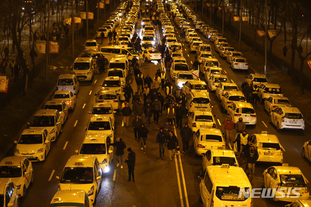 【마드리드=AP/뉴시스】 28일(현지시간) 스페인 마드리드에서 택시 기사들이 카스텔라나 도로를 점거한 채 파업하고 있다.  파업 중인 택시 기사들은 마드리드 내 관계 당국이 우버나 캐비파이 같은 공유 택시 앱 회사에 더 엄격한 규정을 적용할 것을 요구하고 있다.