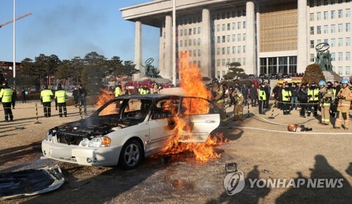 1일 오전 서울 영등포구 국회 잔디밭에서 승용차에 화재가 발생, 소방대원들이 진화 작업을 하고 있다. (출처: 연합뉴스)