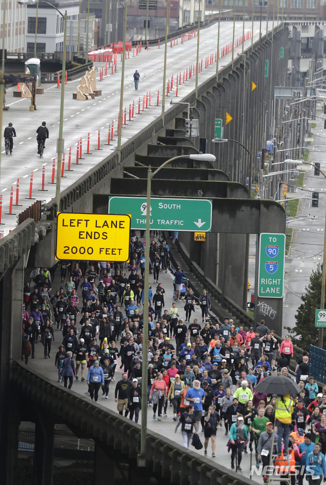 【시애틀=AP/뉴시스】2일(현지시간) 미 워싱턴주 시애틀에서 SR99 터널이 완공돼 4일 있을 일반인 개통을 앞두고 기념 8km 달리기 대회가 열린 가운데 수천 명의 참가자가 알래스칸 웨이 고가교를 통과하고 있다. 이 터널은 지난 수십 년간 시애틀 시민의 주요 통근로였던 노후 '알래스칸 웨이 고가교'를 대체할 것으로 시는 이를 기념해 3일간의 고별 기념행사를 열고 있다.